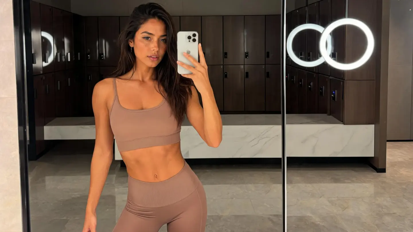 Créatrice fitness prenant un selfie dans le miroir d’un vestiaire de salle de sport