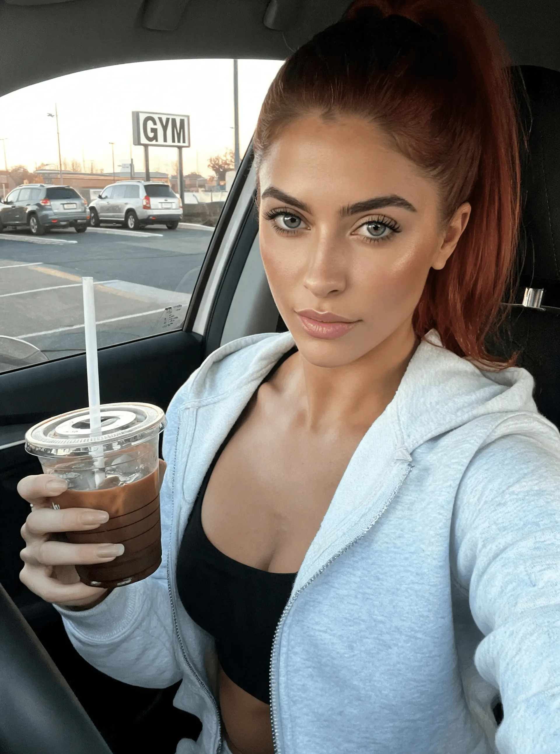 Femme tenant du café glacé à l'extérieur d'une salle de sport